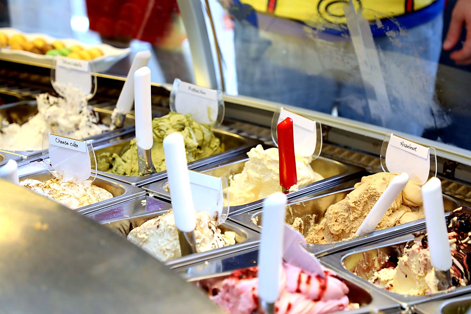 Gelato display case with pistachio, hazelnut and cheesecake flavors